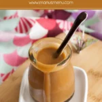 Jar of homemade Miso Caramel Sauce on a small white tray.