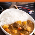 Close-up of Japanese beef curry with a smooth sauce coating beef, carrots, and potatoes.