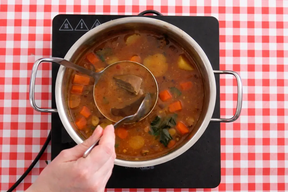 Curry roux and milk being added to the pot to thicken the sauce.
