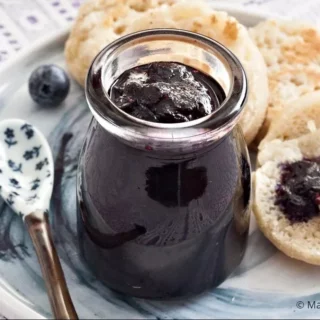 Close-up of blueberry jam spread over crumpets for breakfast.