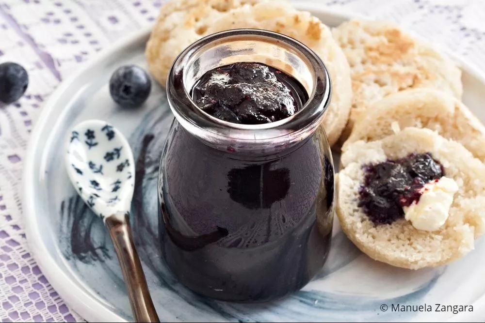 Close-up of blueberry jam spread over crumpets for breakfast.