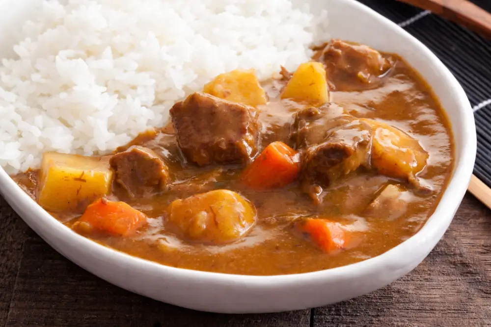 Close-up of low fodmap beef curry with soft potatoes, carrots, and thick sauce.