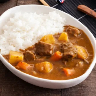 Bowl of low fodmap japanese curry served with white rice, beef, carrots, and potatoes.