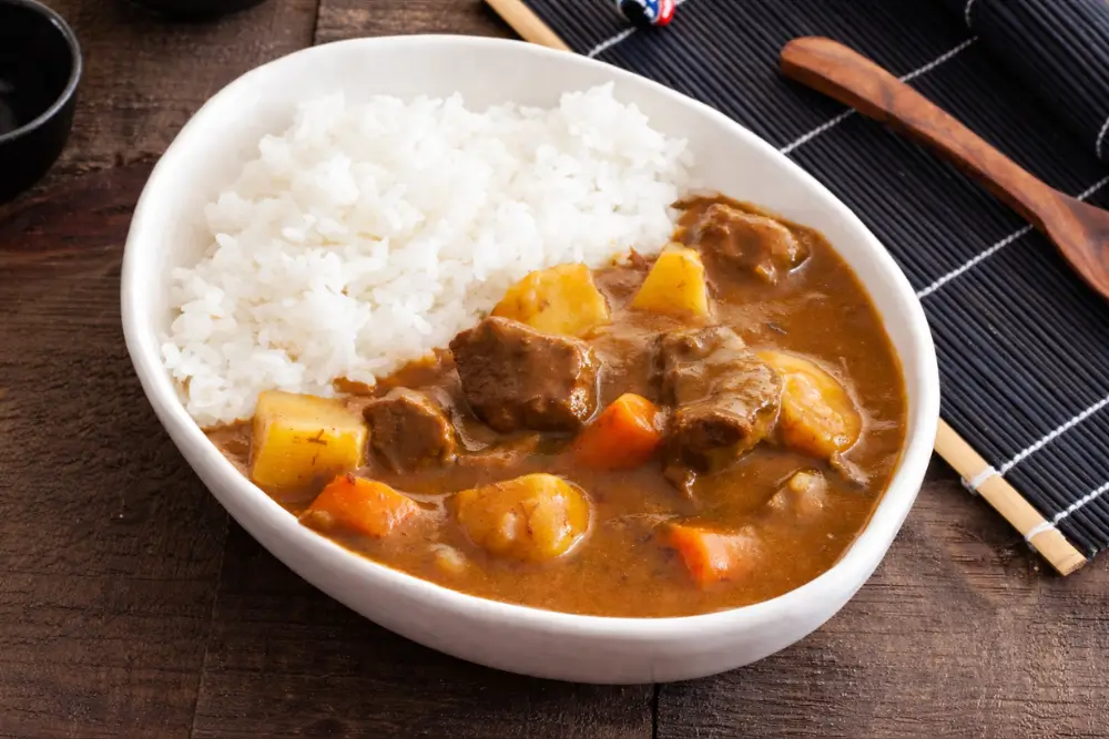 Bowl of low fodmap japanese curry served with white rice, beef, carrots, and potatoes.