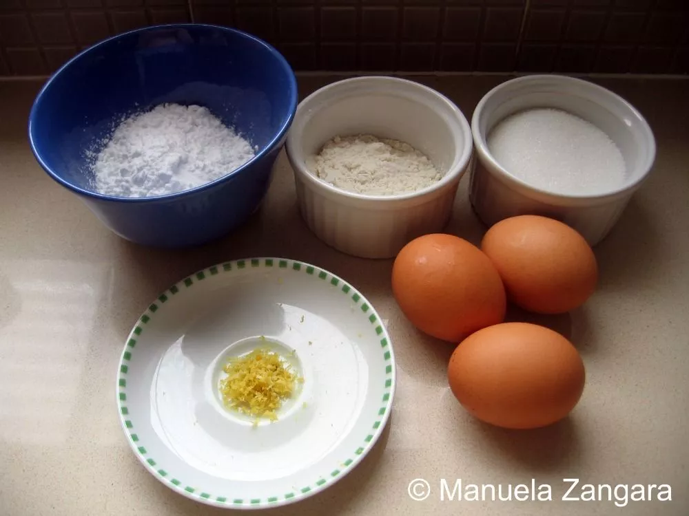 Ingredients for Pan di Spagna including eggs, sugar, flour, potato flour, and lemon zest.