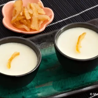 Two glasses of chilled yuzu panna cotta on a blue serving tray.