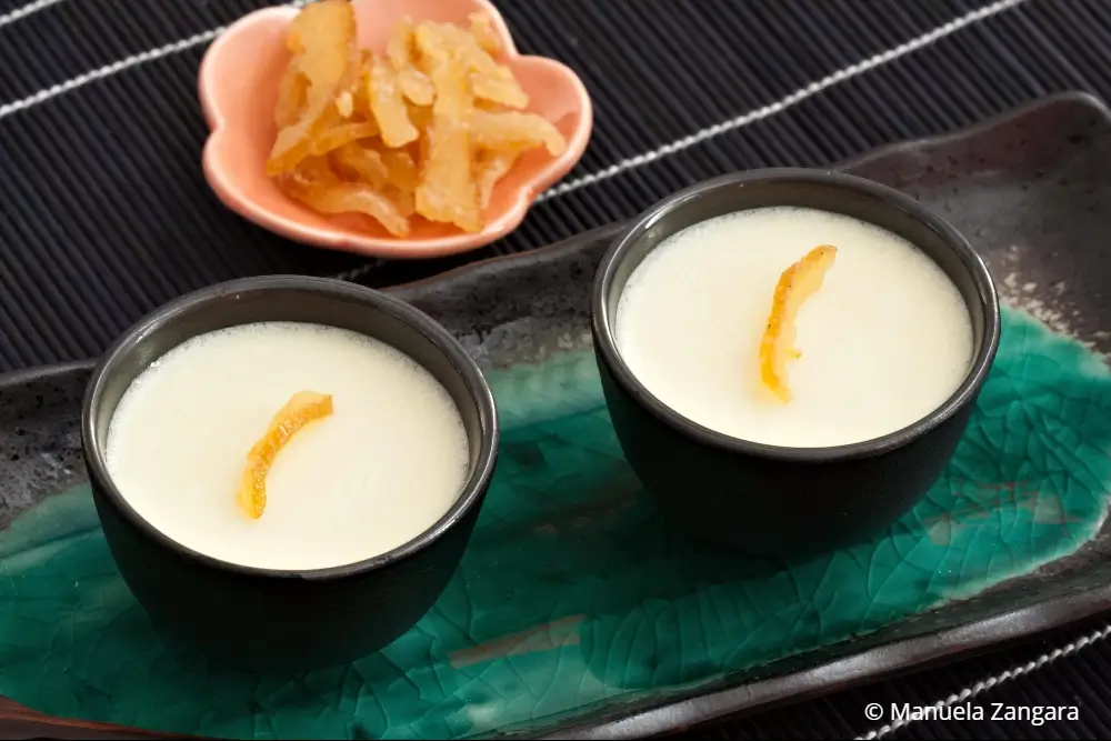 Two glasses of chilled yuzu panna cotta on a blue serving tray.