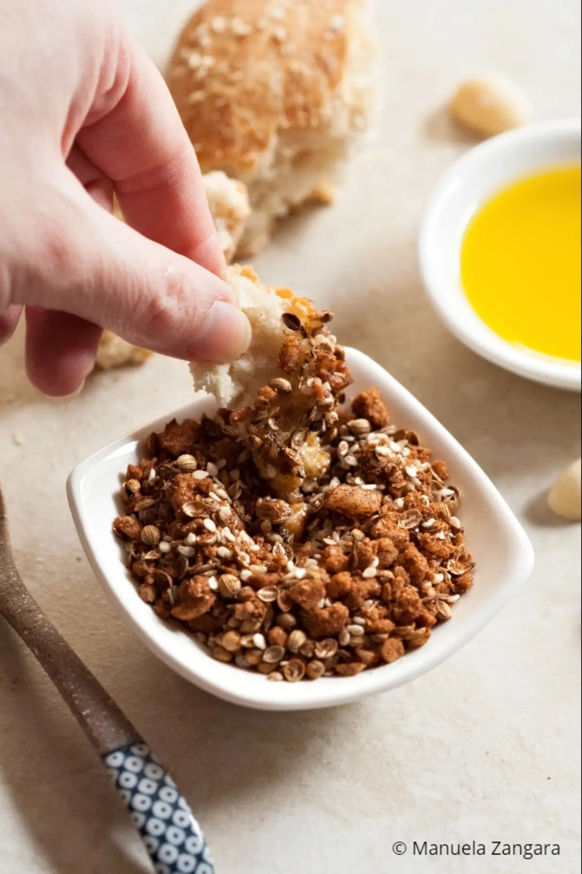 Bread dipped into olive oil and dukkah served for sharing.