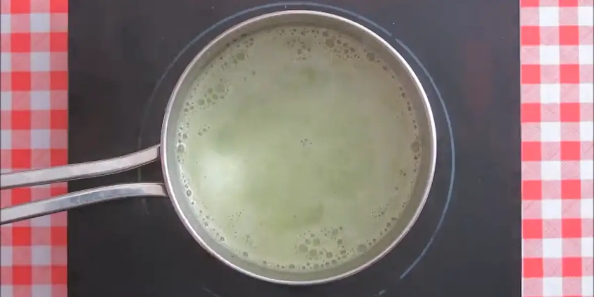 Heating the milk, cream, sugar, and matcha in a pot until combined.