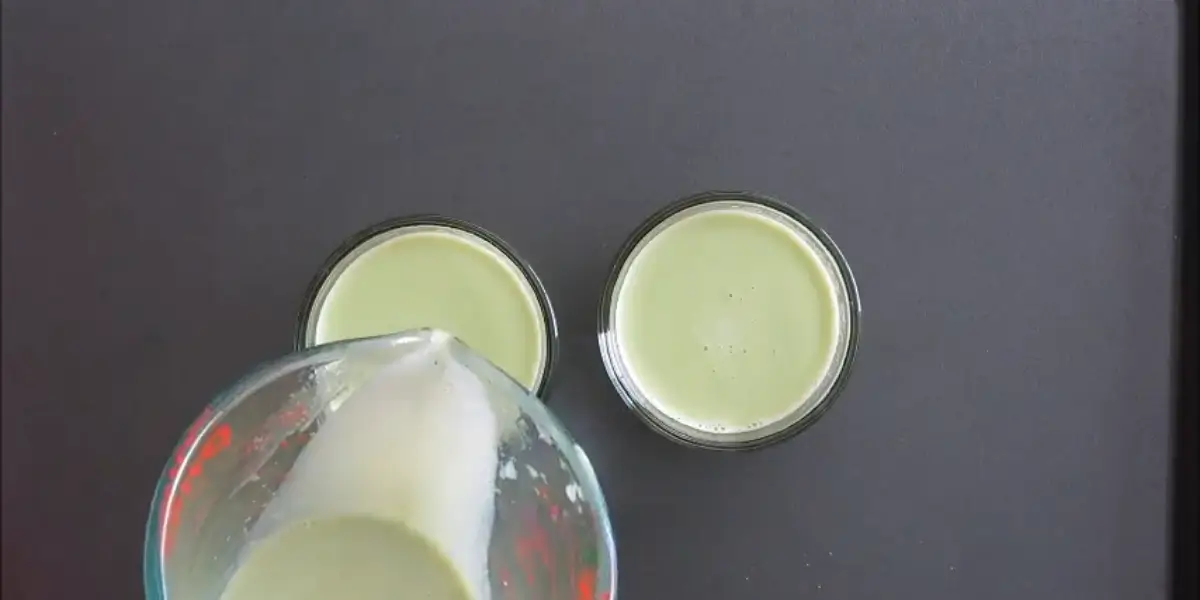 Pouring the warm matcha cream mixture into small glasses.