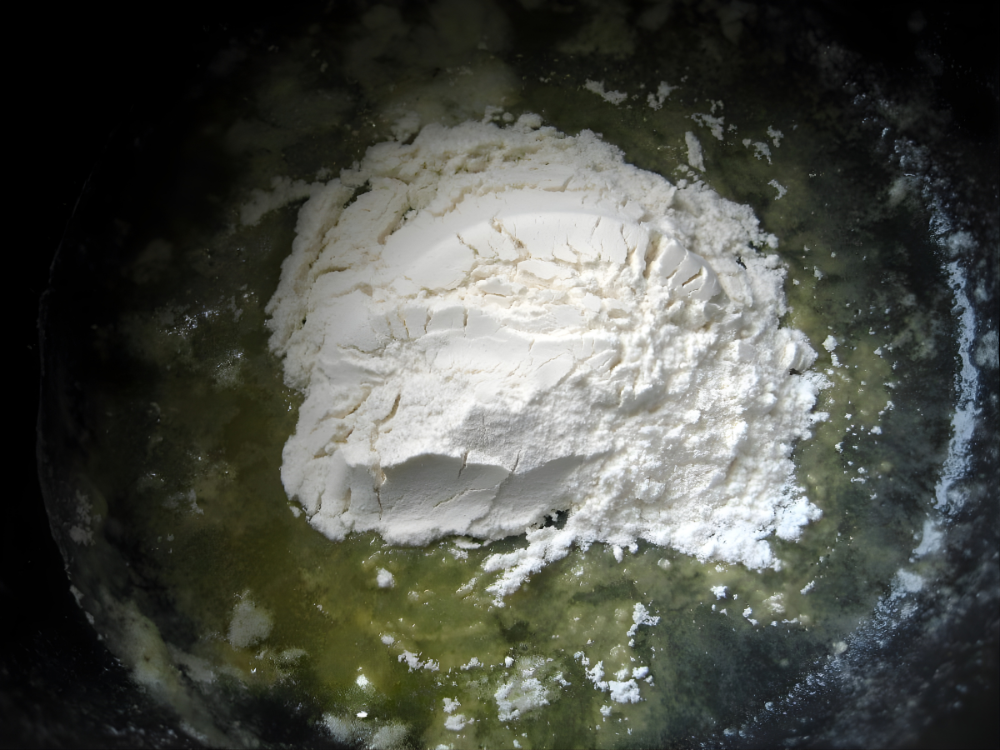 Flour added to melted butter to form the base of the roux.