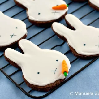 Chocolate cookies decorated with smooth royal icing shaped like Miffy faces.