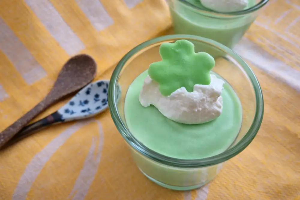 Green Mint Chocolate Shooters topped with whipped cream and shamrock decoration.