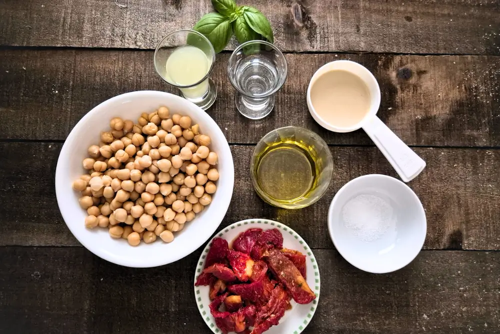 Overhead view of chickpeas, sun-dried tomatoes, olive oil and lemon.