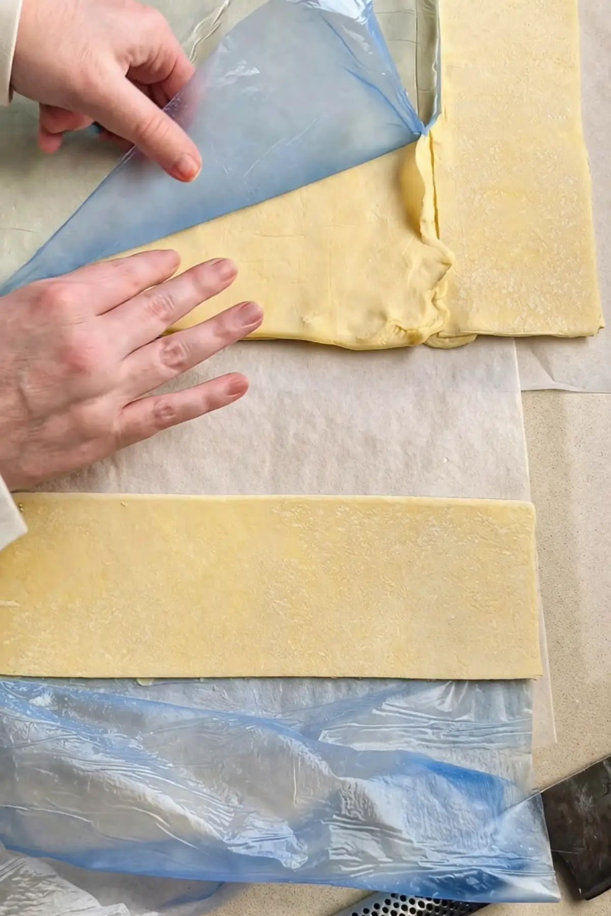 Cutting puff pastry into strips on a lined surface.