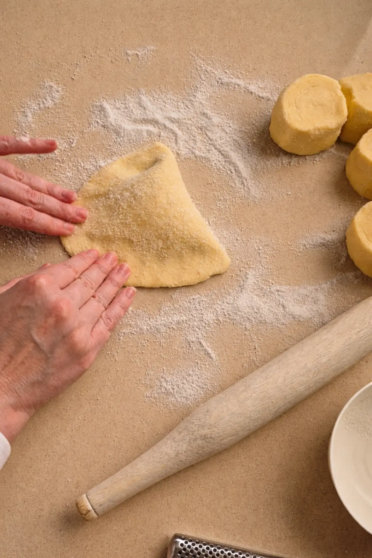 Folding the dough over the filling and pressing the edges to seal.