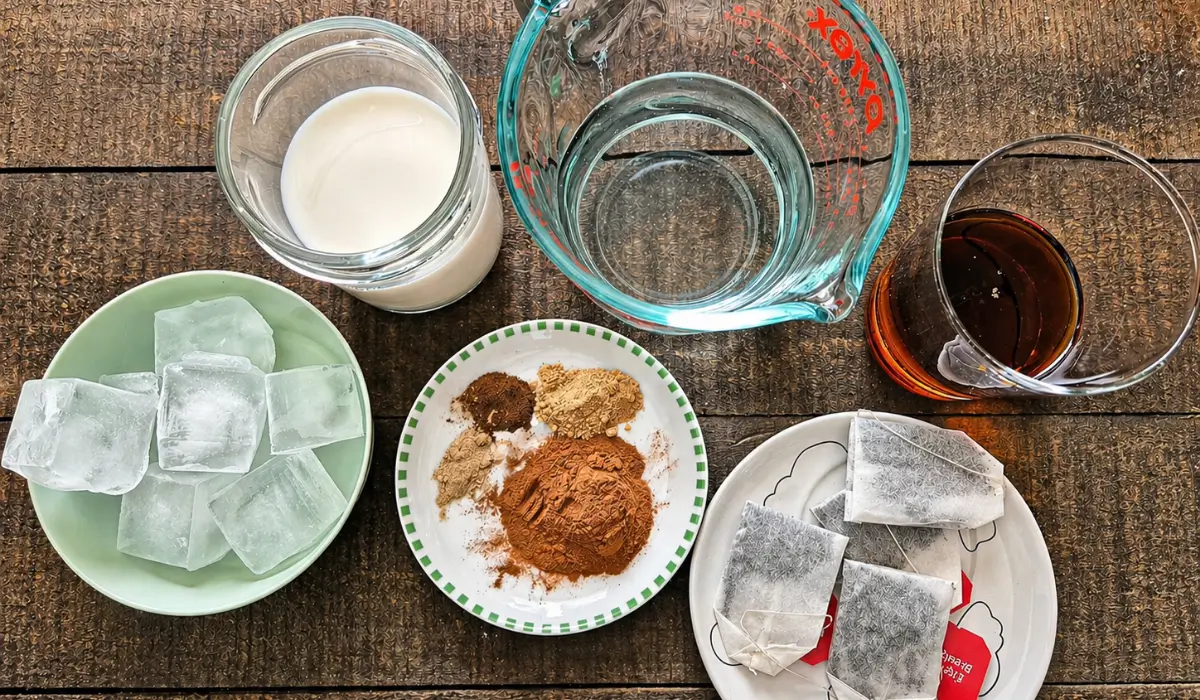 Ingredients for a homemade chai latte arranged on a table.