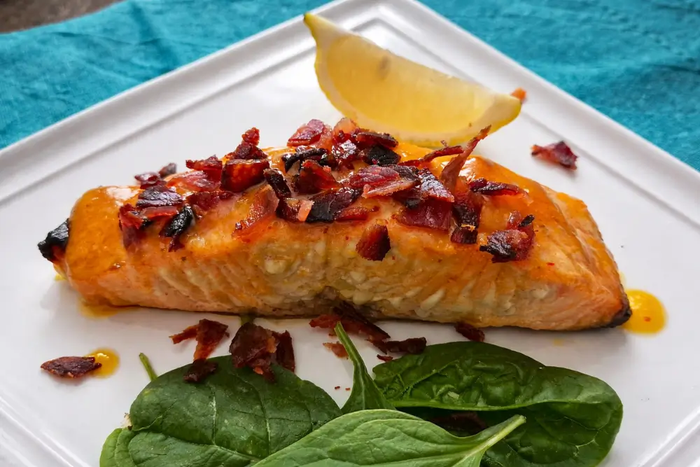 Maple and Sriracha Salmon with Bacon Crumbs served with crispy topping and lemon on the side.