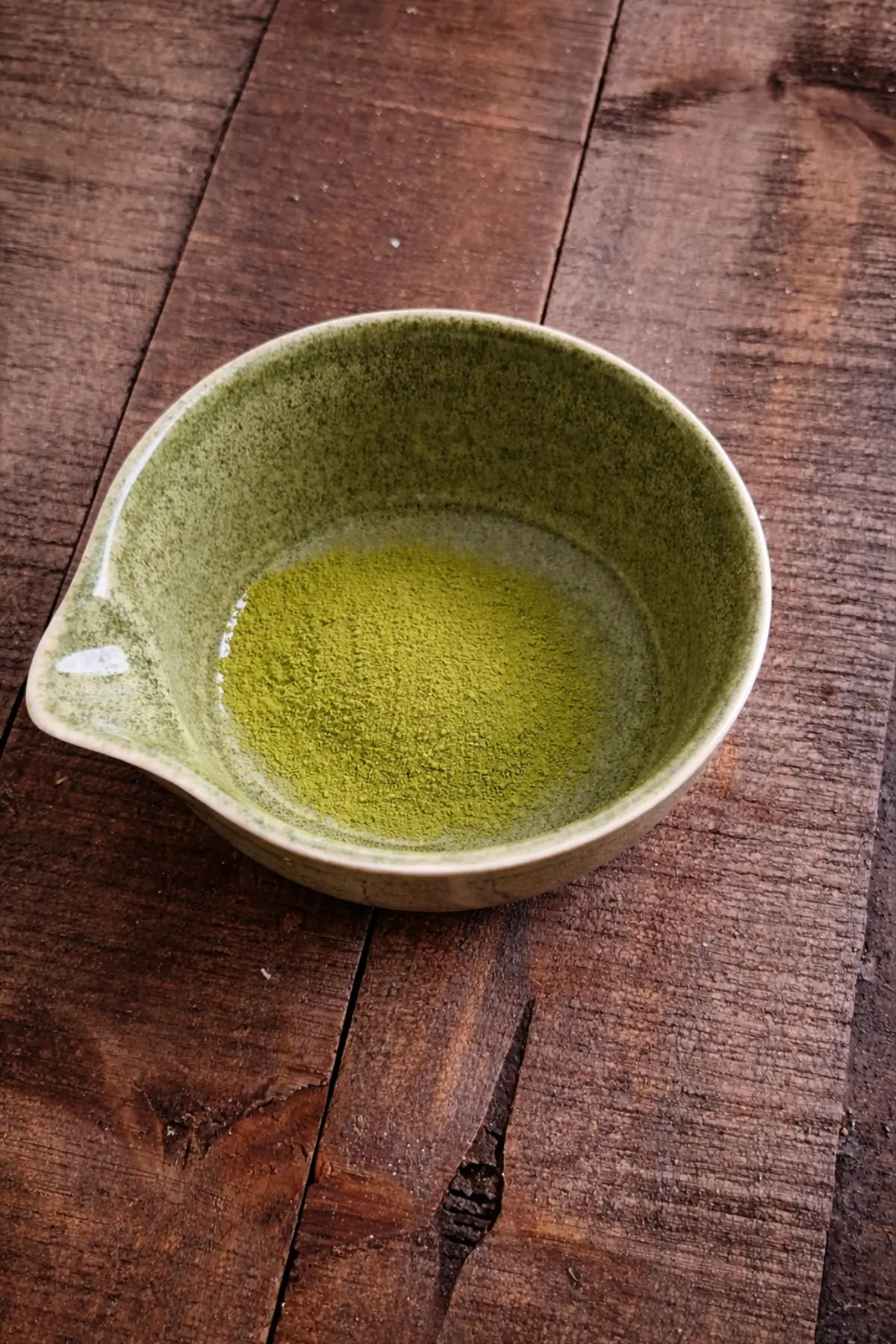 Smooth matcha mixture resting in a small pouring bowl.