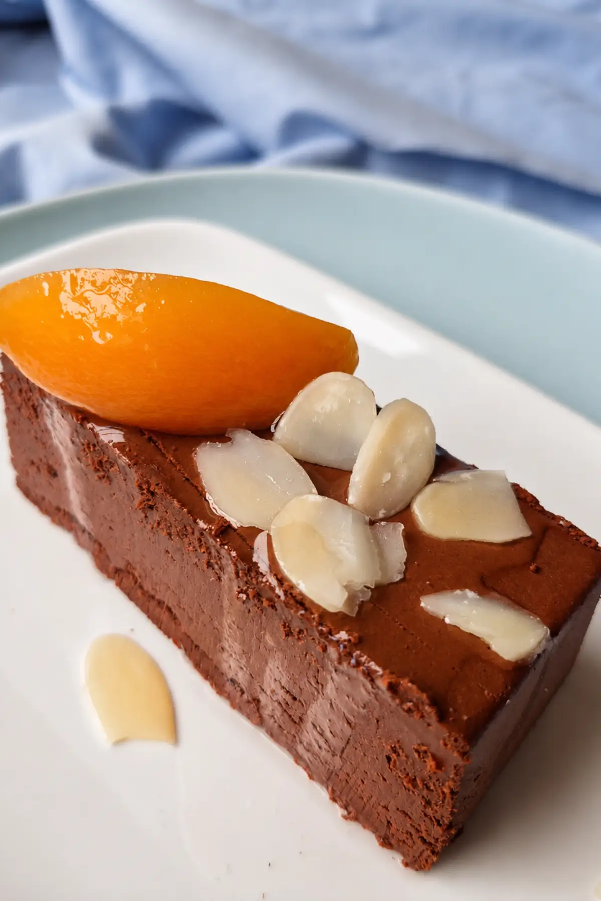 Chilled chocolate dessert garnished with peach slices and almond flakes.