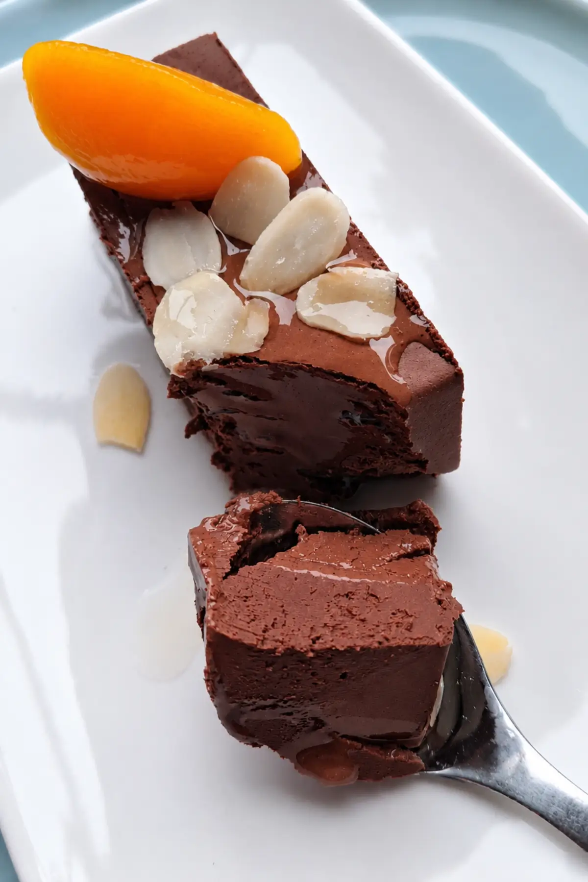 Spoon lifting a creamy piece of chocolate peach dessert.