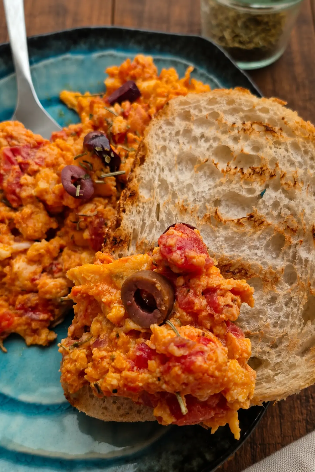 Toasted sourdough topped with creamy tomato eggs, olives, and herbs.
